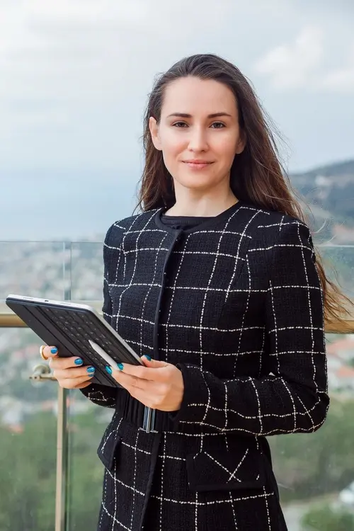 blogger-girl-is-looking-camera-by-holding-planshet-computer-against-background-city-view